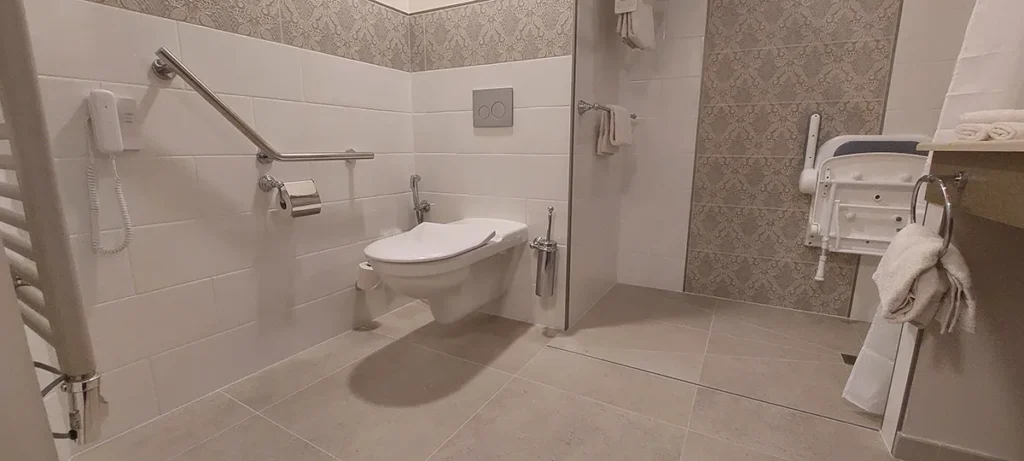 Bagno accessibile (PMR) al Disneyland Hotel con sedile per doccia e maniglioni di sostegno